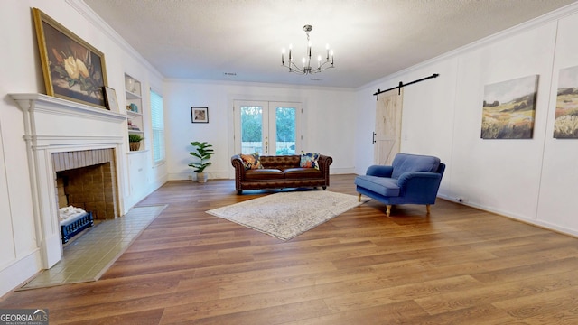 living area featuring a chandelier, light wood-style floors, crown molding, and a textured ceiling