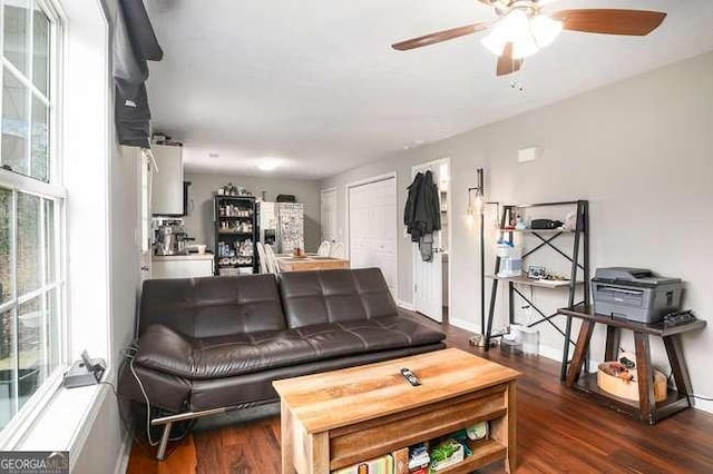 living area featuring baseboards, wood finished floors, and ceiling fan