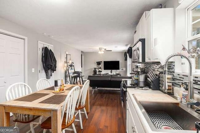 dining space with dark wood finished floors and ceiling fan
