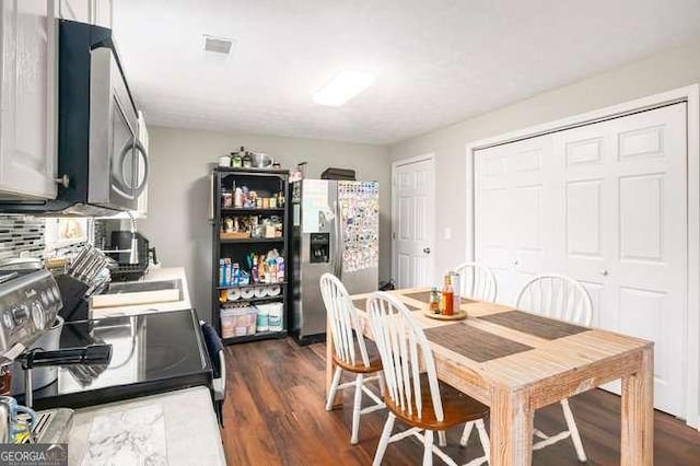 dining space with visible vents and dark wood-style floors