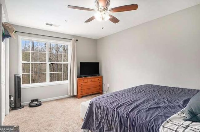 carpeted bedroom featuring visible vents, a ceiling fan, and baseboards