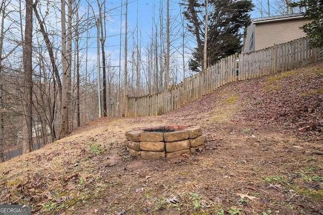 view of yard with fence and a fire pit
