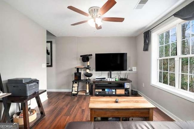living room featuring wood finished floors, a ceiling fan, baseboards, and visible vents