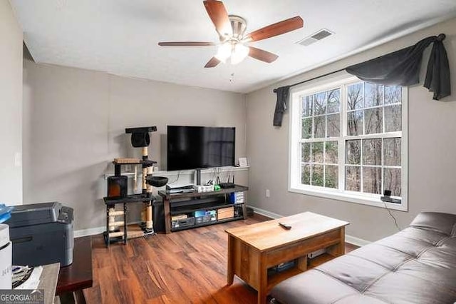 living room with visible vents, baseboards, a ceiling fan, and wood finished floors