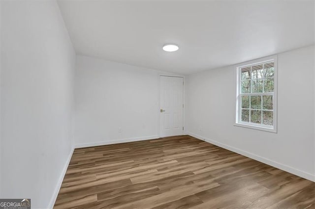 unfurnished room featuring baseboards and wood finished floors