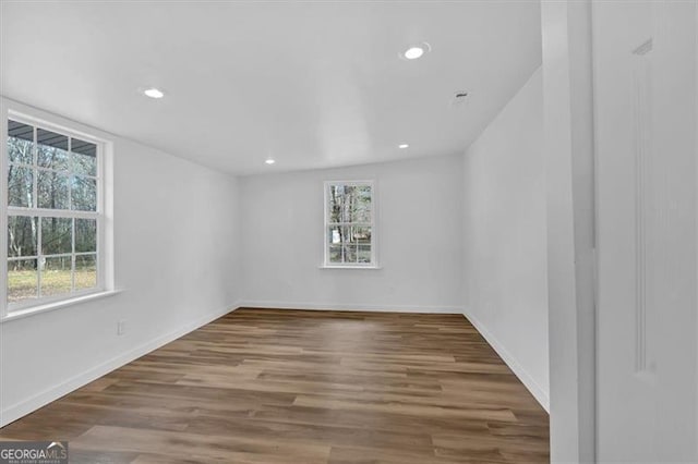 spare room with recessed lighting, baseboards, and wood finished floors