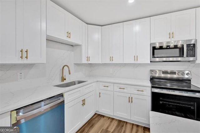 kitchen with a sink, appliances with stainless steel finishes, and white cabinets