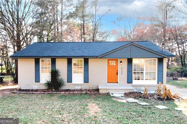 single story home featuring crawl space, a front lawn, and brick siding