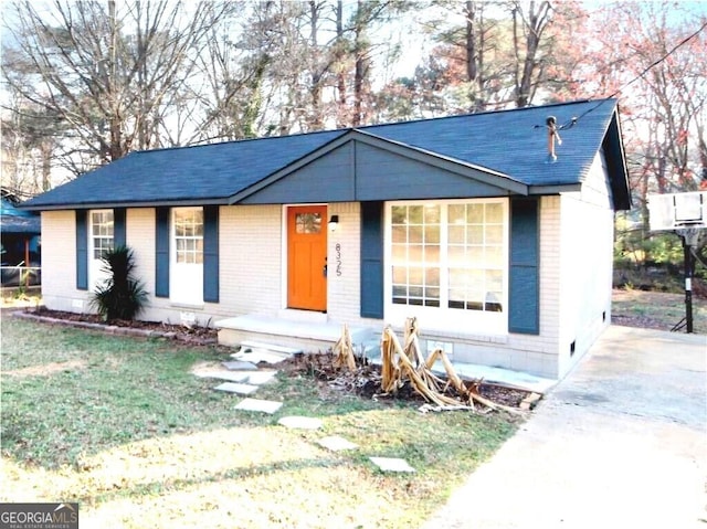 view of front of house featuring a front yard and brick siding