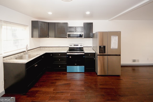 kitchen with visible vents, a sink, stainless steel appliances, dark wood-type flooring, and light countertops