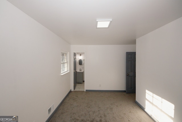 unfurnished room featuring light colored carpet, visible vents, and baseboards