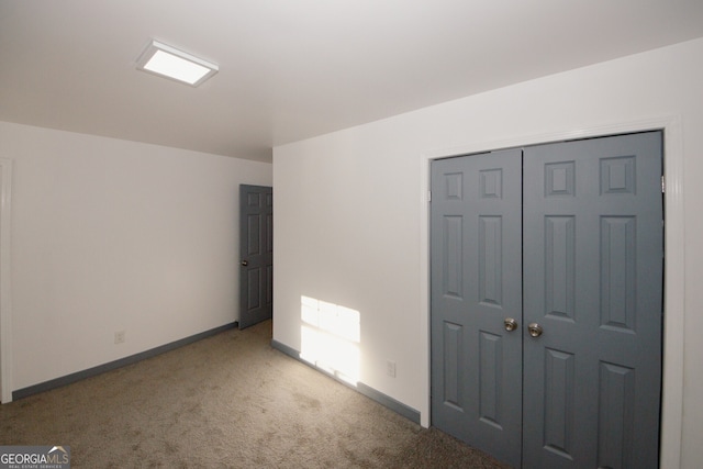 unfurnished bedroom featuring a closet, radiator heating unit, baseboards, and carpet floors