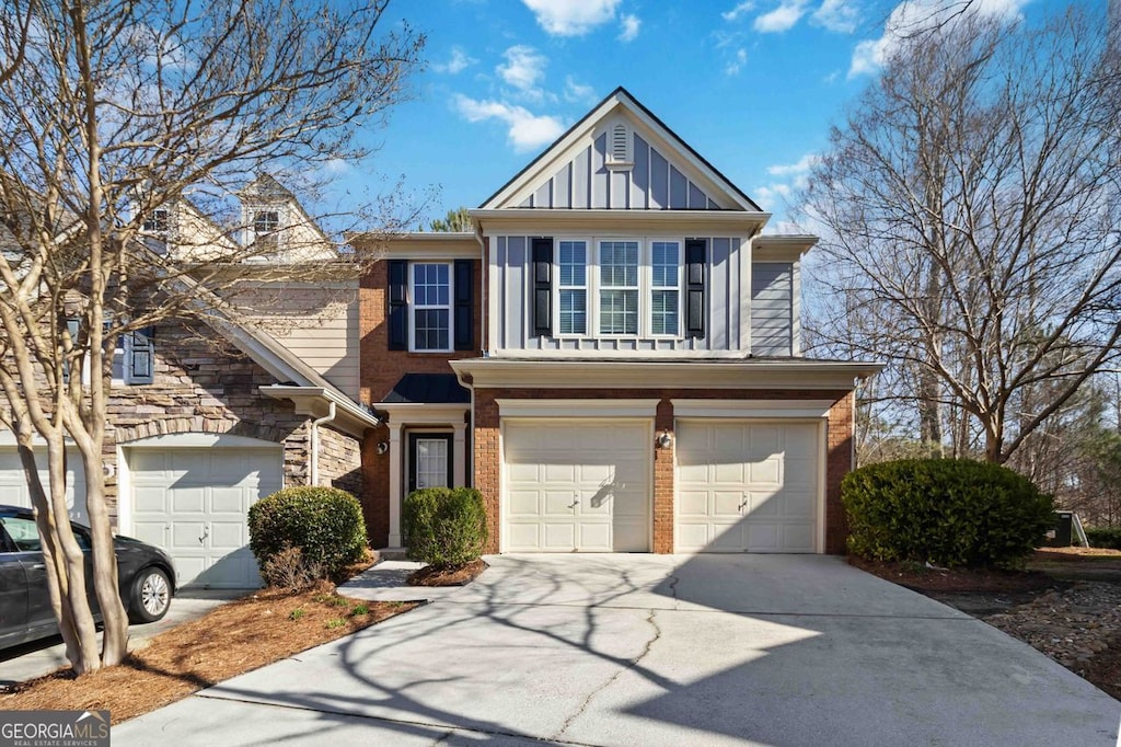 view of front facade with an attached garage, brick siding, board and batten siding, and driveway