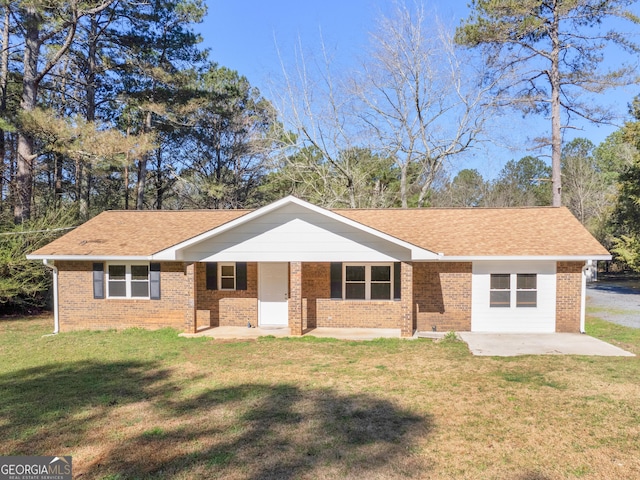 single story home with a front yard, a patio area, brick siding, and a shingled roof