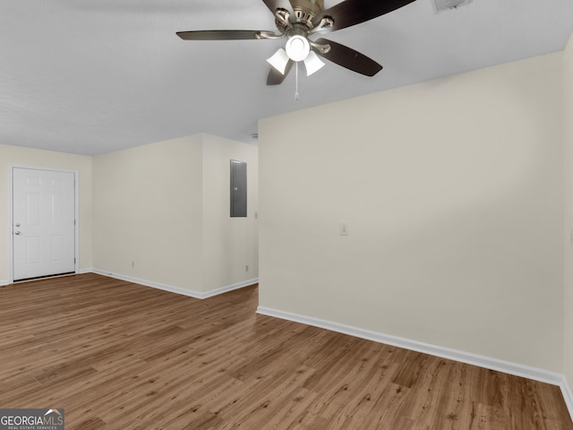 unfurnished living room featuring electric panel, baseboards, wood finished floors, and ceiling fan