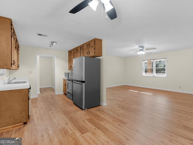 kitchen with brown cabinets, light wood-type flooring, visible vents, and stainless steel appliances