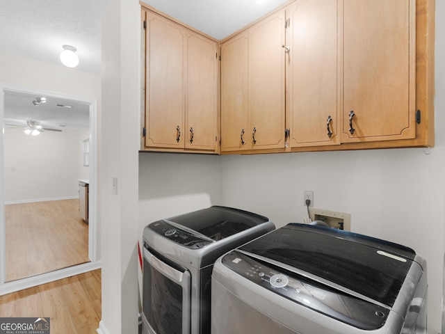 washroom with washer and clothes dryer, cabinet space, light wood-style floors, baseboards, and ceiling fan