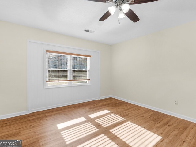 unfurnished room with ceiling fan, visible vents, baseboards, and light wood-style flooring