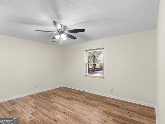 unfurnished room with visible vents, a ceiling fan, a textured ceiling, light wood finished floors, and baseboards