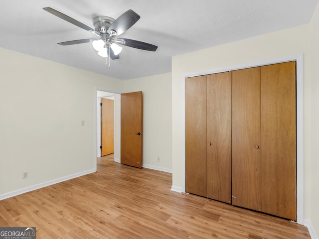 unfurnished bedroom with light wood finished floors, ceiling fan, a closet, and baseboards