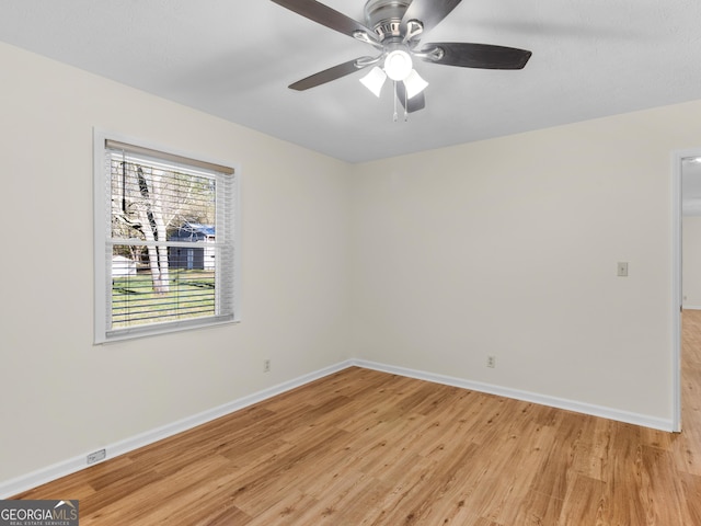 unfurnished room featuring a ceiling fan, baseboards, and light wood-type flooring