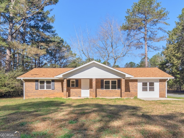 ranch-style home featuring brick siding, a front lawn, and roof with shingles