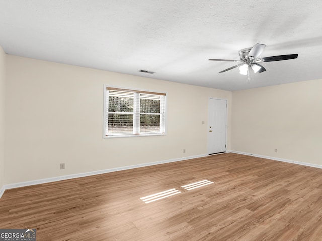 unfurnished room with visible vents, a ceiling fan, a textured ceiling, light wood finished floors, and baseboards