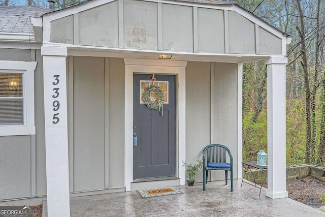 view of exterior entry featuring a shingled roof