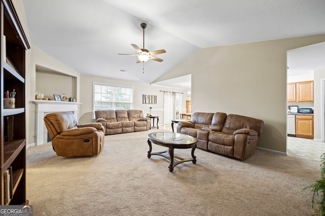 living room with a ceiling fan, lofted ceiling, carpet, and a fireplace