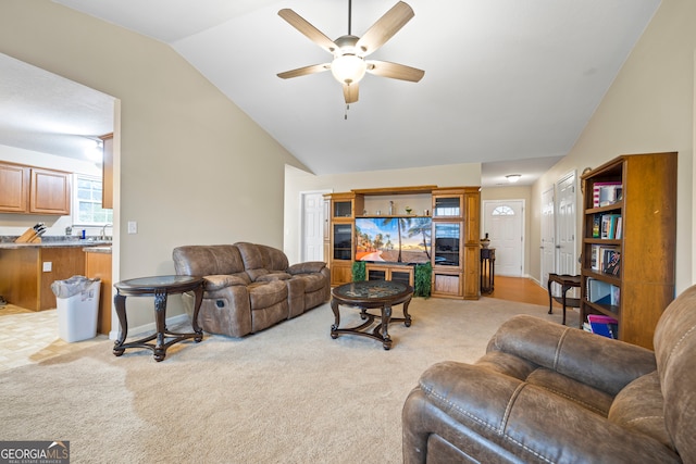 living room with light colored carpet, a ceiling fan, and vaulted ceiling