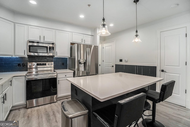 kitchen featuring white cabinets, appliances with stainless steel finishes, and light wood-style floors