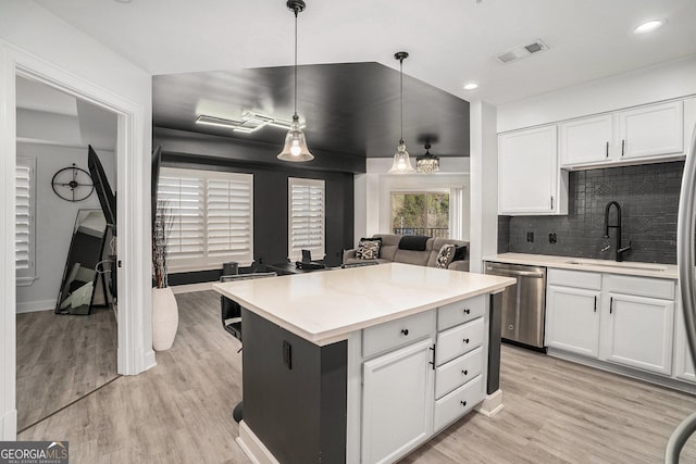 kitchen featuring visible vents, a sink, backsplash, white cabinets, and dishwasher