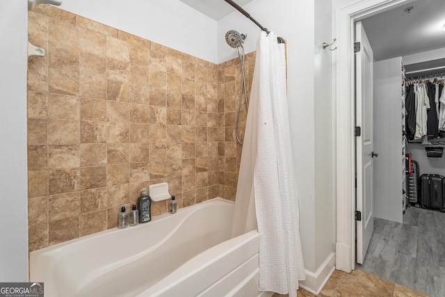 full bath with shower / bath combo with shower curtain and a spacious closet