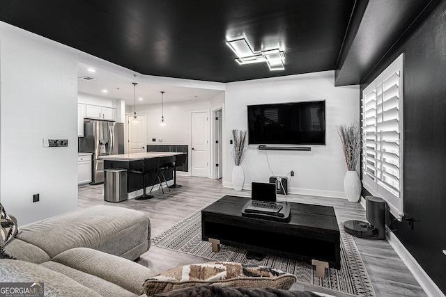 living room featuring recessed lighting, light wood-style flooring, and baseboards