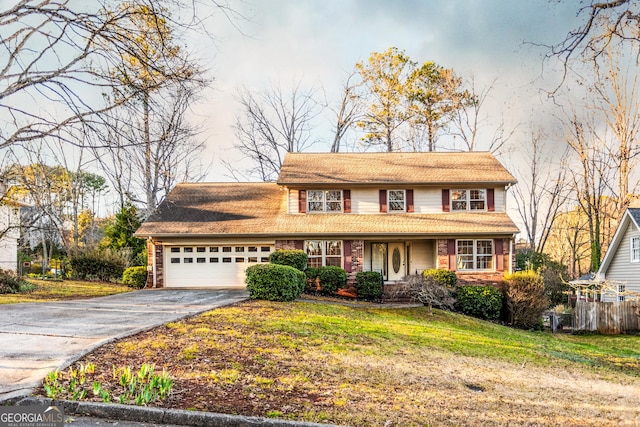 traditional home with aphalt driveway, a garage, and a front lawn