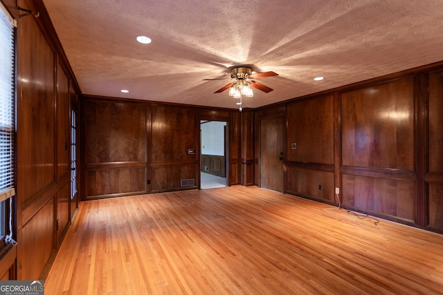 unfurnished room with visible vents, a textured ceiling, a ceiling fan, and light wood finished floors