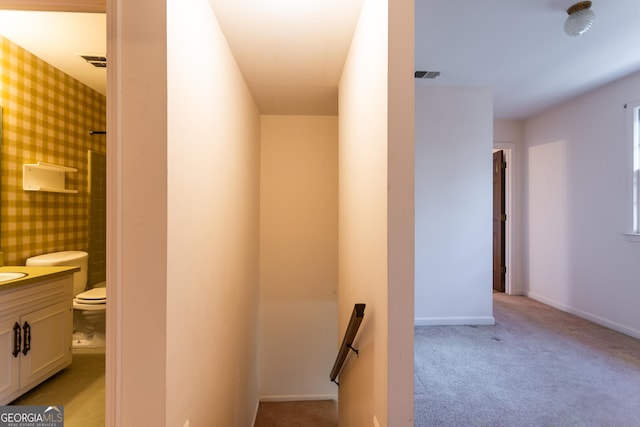 corridor with visible vents, light carpet, baseboards, and wallpapered walls