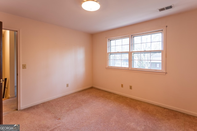 carpeted empty room featuring visible vents and baseboards