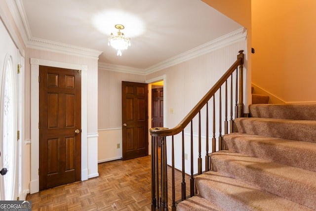 foyer entrance with stairway, baseboards, a notable chandelier, and ornamental molding