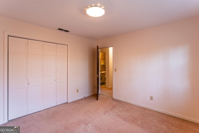 unfurnished bedroom featuring a closet, visible vents, baseboards, and carpet floors