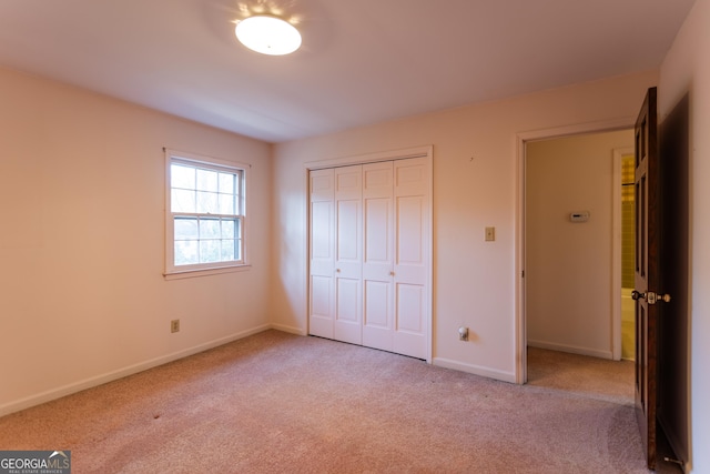 unfurnished bedroom with a closet, baseboards, and carpet