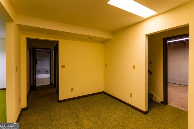 empty room featuring stairway, baseboards, and dark carpet