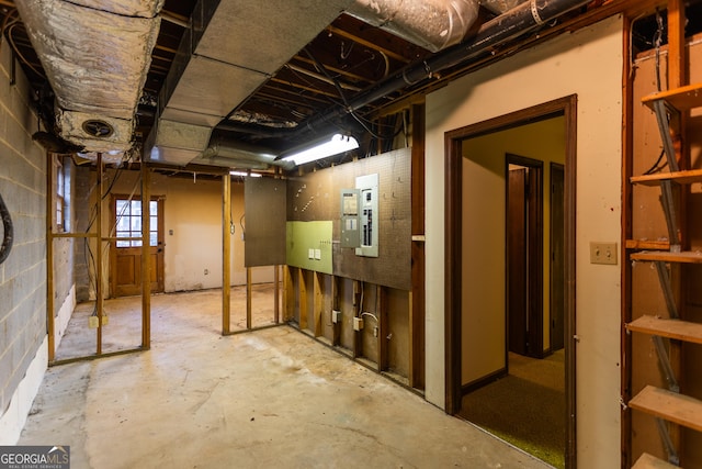 basement featuring electric panel and concrete block wall