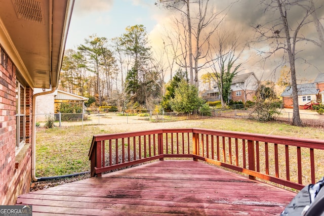 wooden terrace with a yard and a fenced backyard