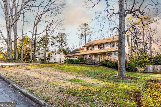 view of front facade featuring a front yard and fence