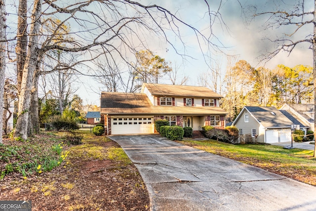 view of front of house with a front yard, an attached garage, and driveway