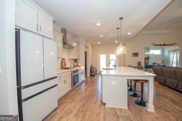 296 Beavers Rd, Grantville, GA 30220 - kitchen with freestanding refrigerator, stainless steel oven, wall chimney exhaust hood, open floor plan, and a sink