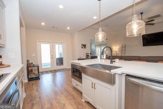 kitchen featuring visible vents, a sink, french doors, appliances with stainless steel finishes, and light wood finished floors