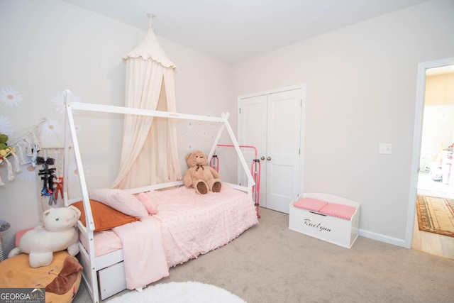 carpeted bedroom featuring a closet and baseboards