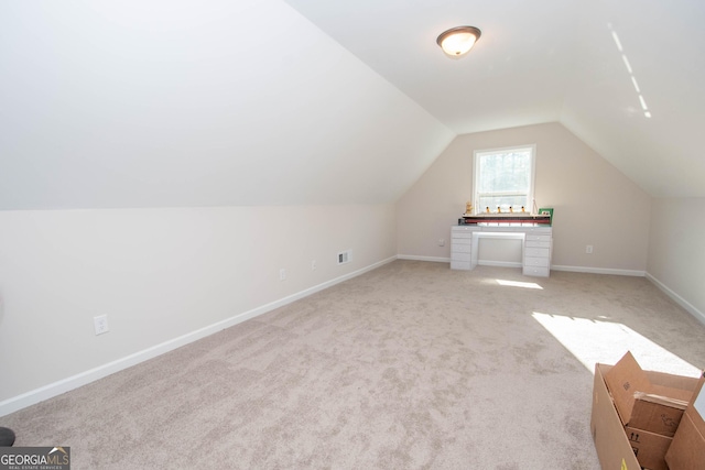 additional living space featuring light carpet, visible vents, baseboards, and vaulted ceiling